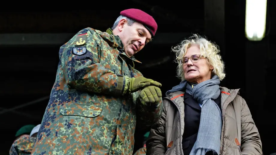 Das Bild zeigt den auf seine Uhr blickenden Heeresinspekteur Alfons Mais und Verteidigungsministerin Christine Lambrecht.