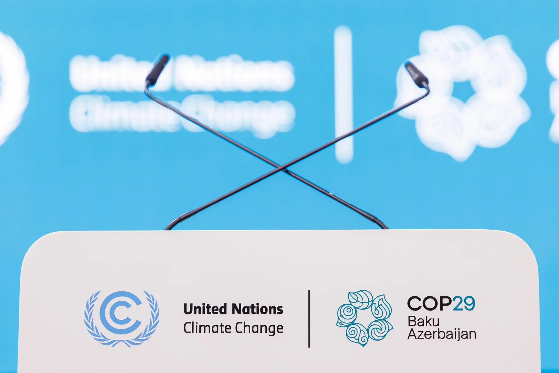 COP29 in Baku Rednerpult mit zwei Mikrofonen vor hellblauem Hintergrund
