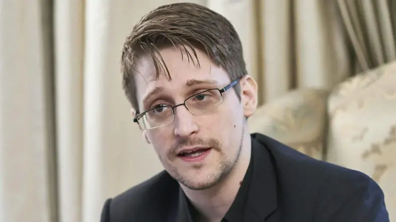 Edward Snowden im schwarzen Anzug gestikuliert