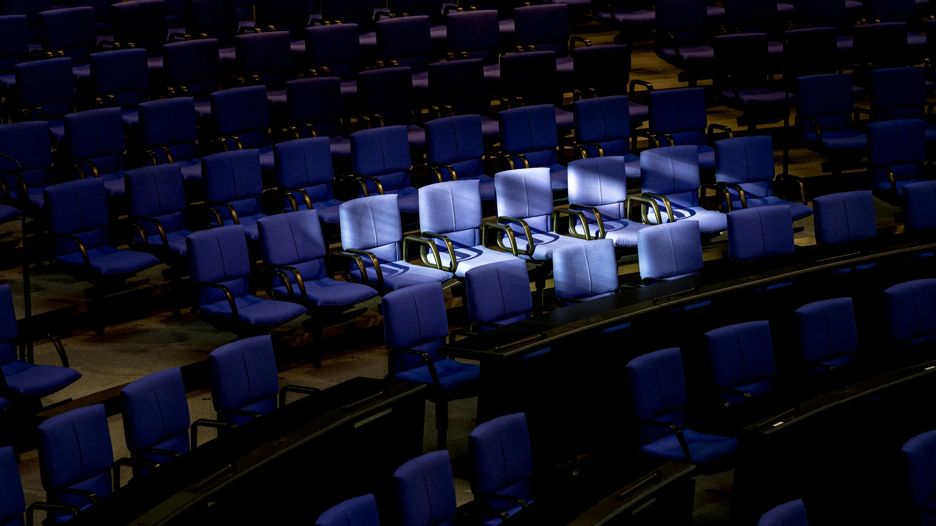 Licht fällt auf leere Stühle im Plenarsaal