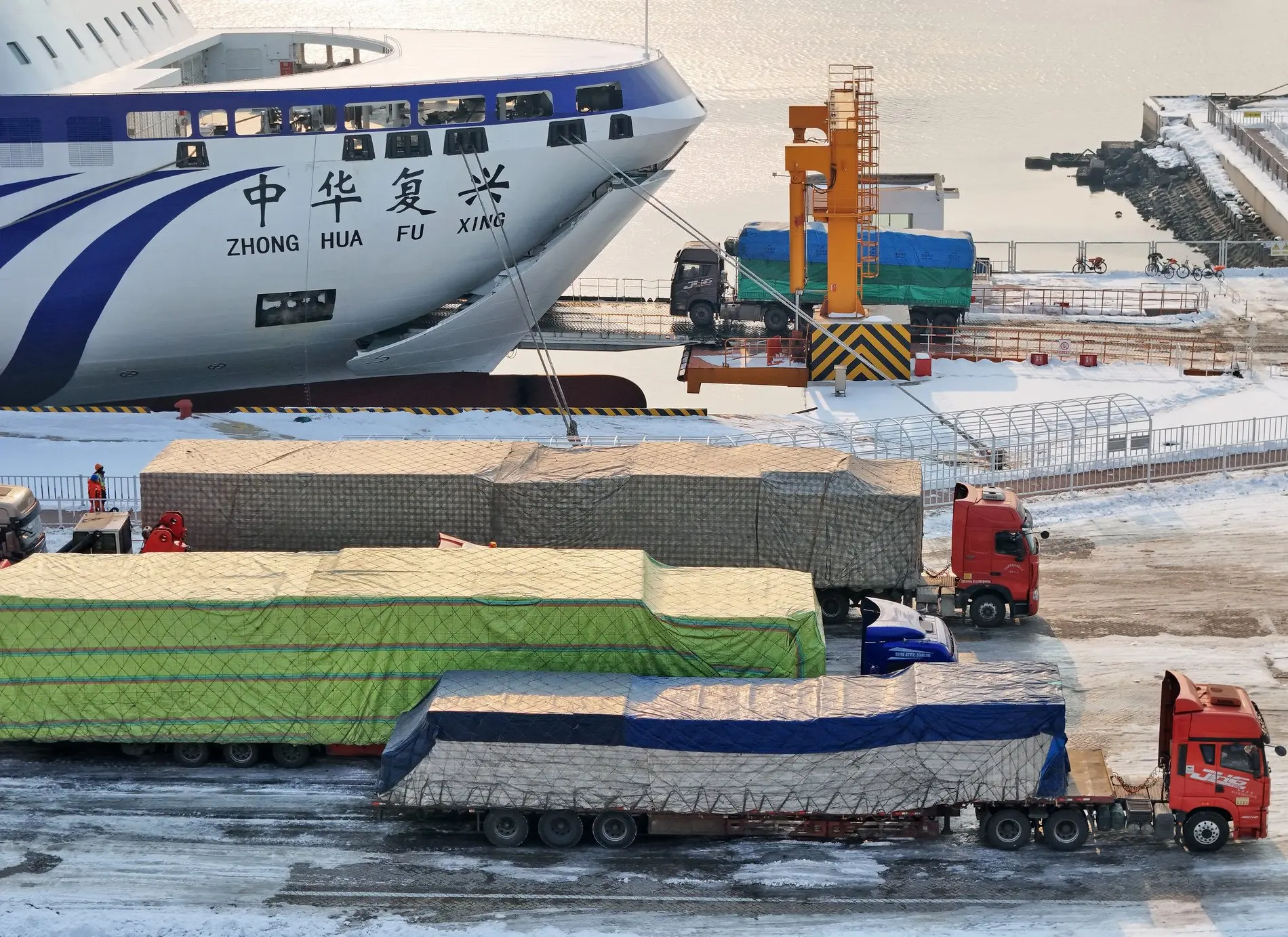 Ein großes Schiff steht an einem Hafen vor Containern