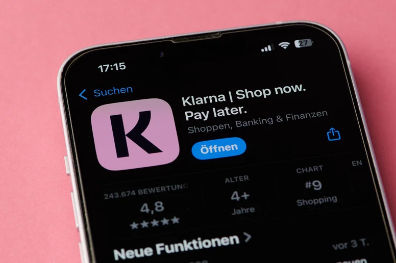 Klarna App-Symbol auf einem Smartphone-Bildschirm auf rosa Hintergrund