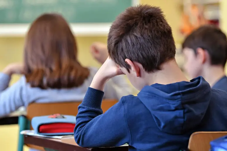 Schülerinnen und Schüler sitzen an ihren Pulten im Klassenraum.