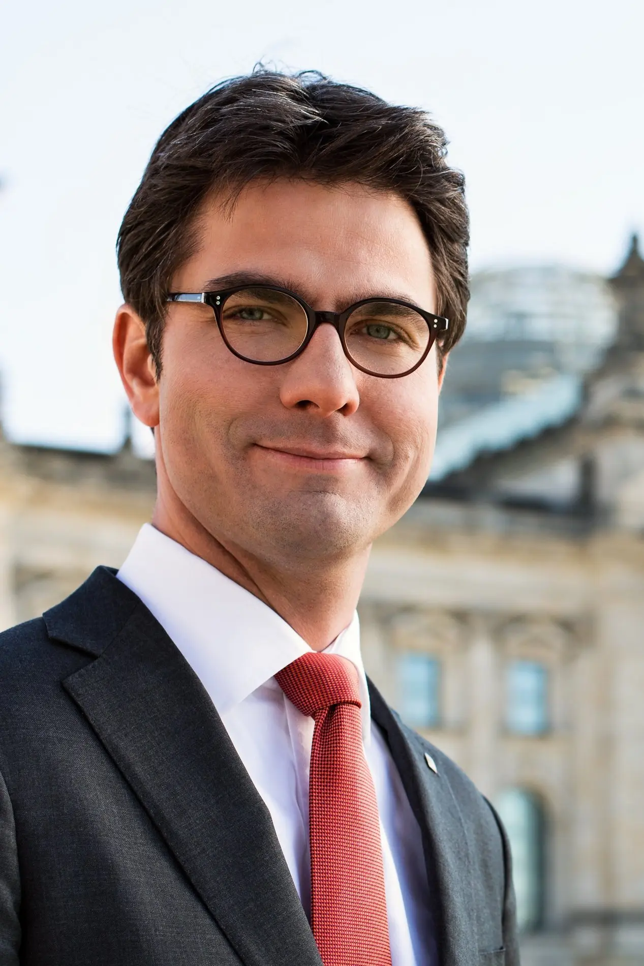 Porträt von Mark Helfrich im Anzug mit Krawatte und Brille.