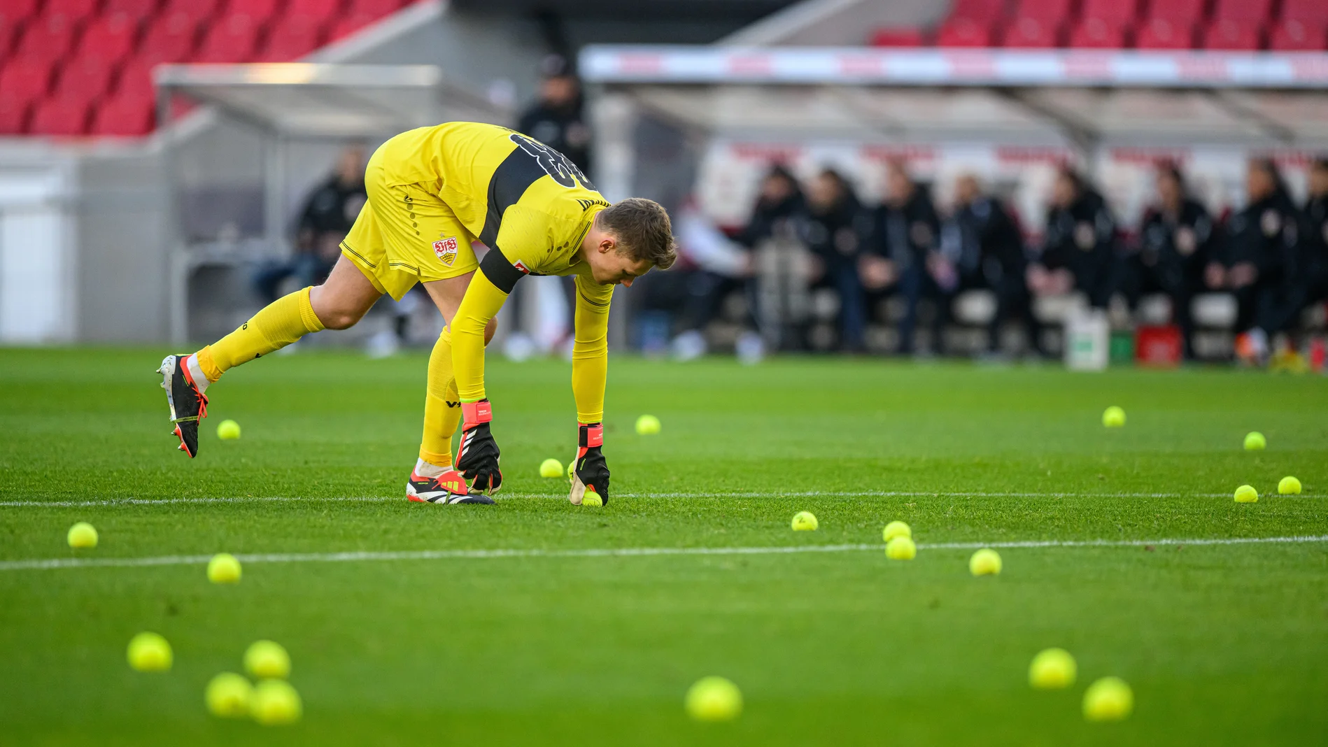Torhüter Alexander Nübel sammelt Tennisbälle auf dem Fußballfeld ein
