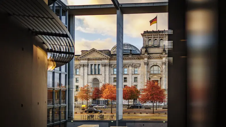 Das Reichstagsgebäude spiegelt sich in einer Scheibe des Paul-Löbe-Haus am frühen Morgen. 