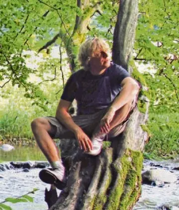 Dominik Eulberg sitzend auf einem Baum