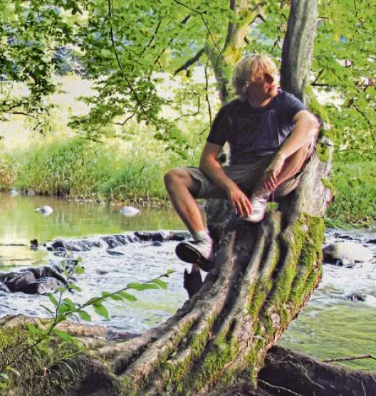 Dominik Eulberg sitzend auf einem Baum