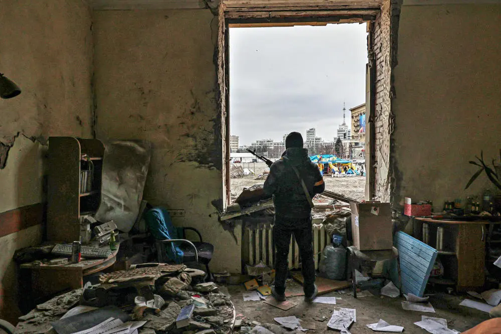 Ein Mitglied der territorialen Verteidigungskräfte der Ukraine steht in der beschädigten Regionalverwaltung in Charkiw nach einem Angriff.