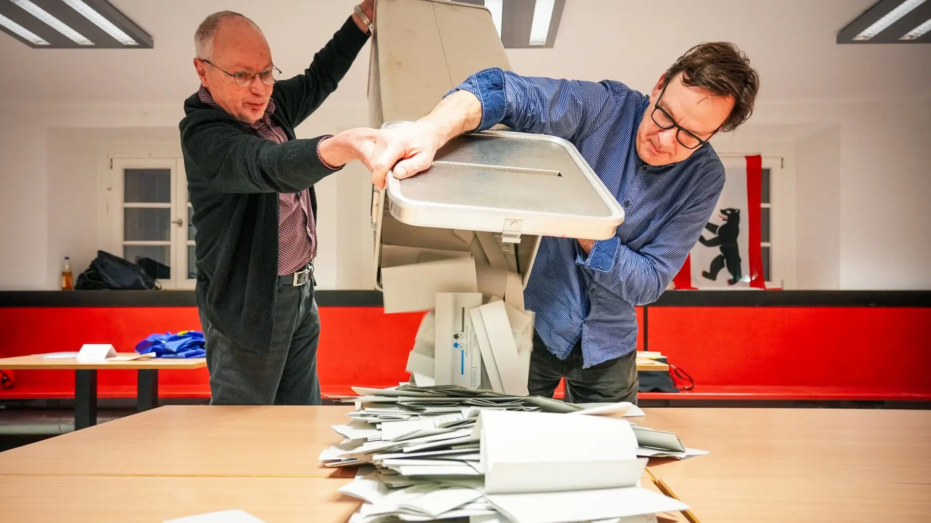 Wahlhelfer leeren bei der Stimmauszählung die Wahlurnen aus.