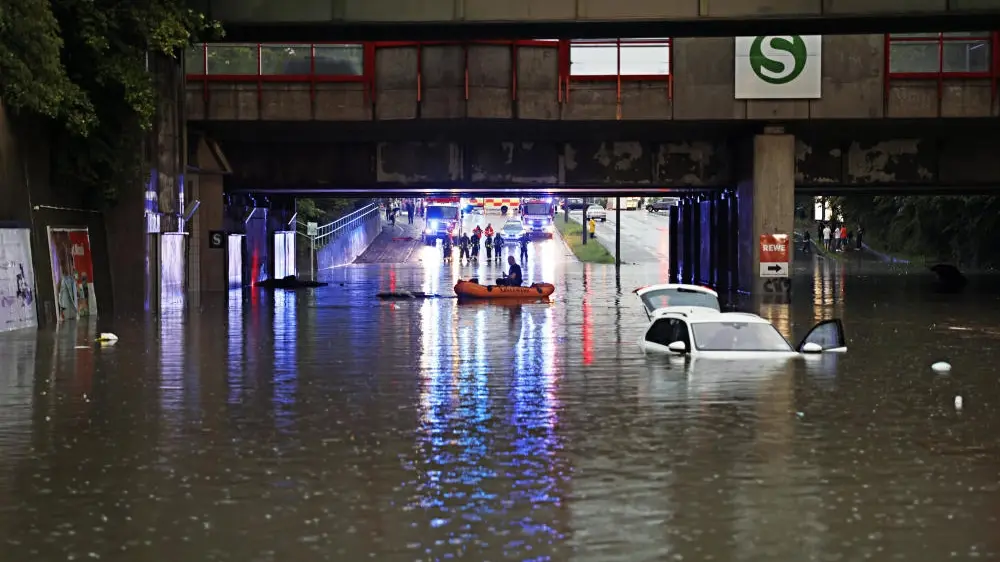 Überflutungen in Nürnberg nach Starkregen Durch Starkregen überschwemmte Straße; ein Auto ist fast komplett versunken.