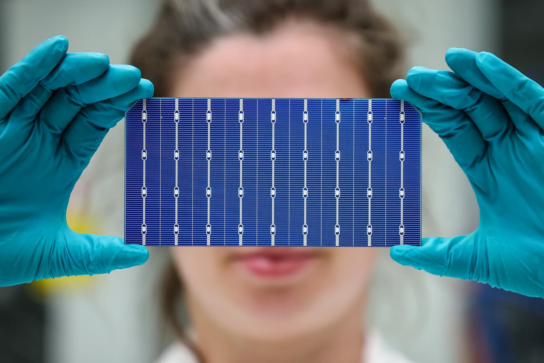 Frau hält eine Solarzelle vor ihr Gesicht