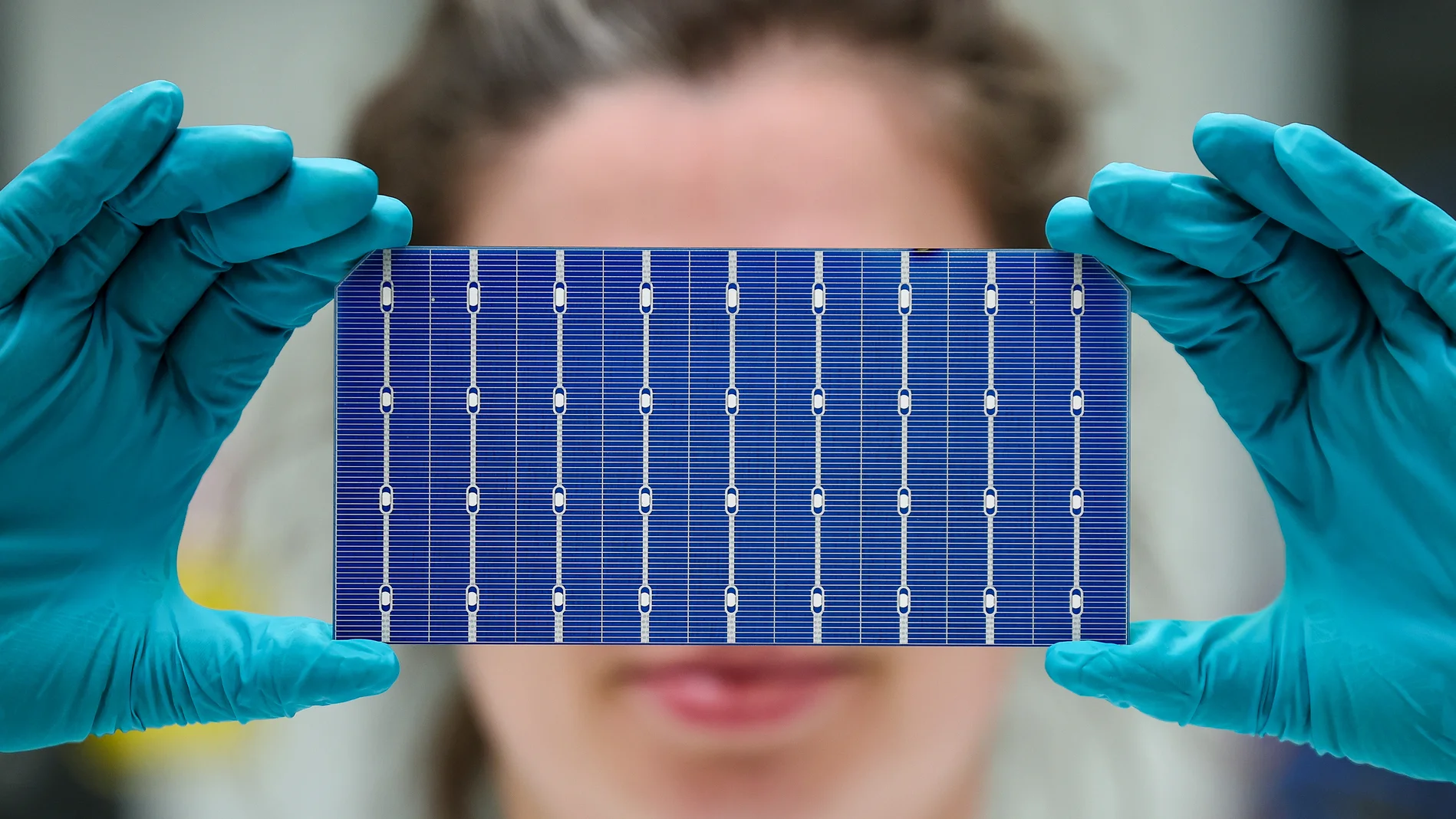 Frau hält eine Solarzelle vor ihr Gesicht