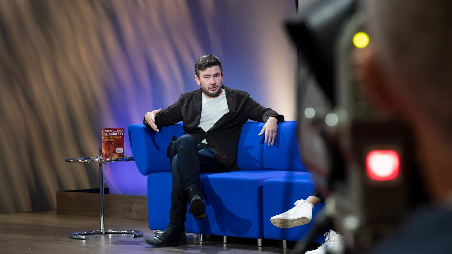 Dmitry Glukhovsky Dmitry Glukhovsky auf einem blauen Sofa auf der Frankfurter Buchmesse 2022