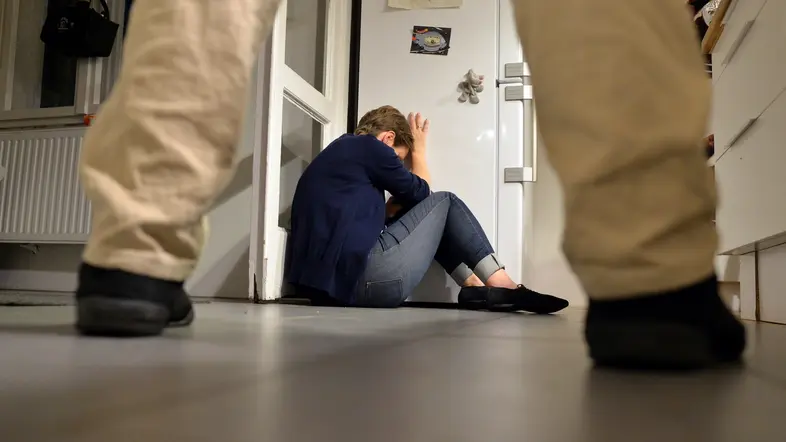 Symbolbild: Eine Frau versucht, sich vor der Gewalt eines Mannes zu schützen.