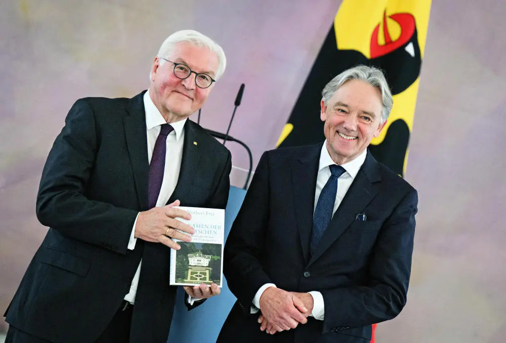 Buchpräsentation Steinmeier hält Norbert Freis Buch, beide lächeln.