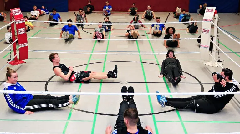 Sportler machen Übungen in einer Sporthalle