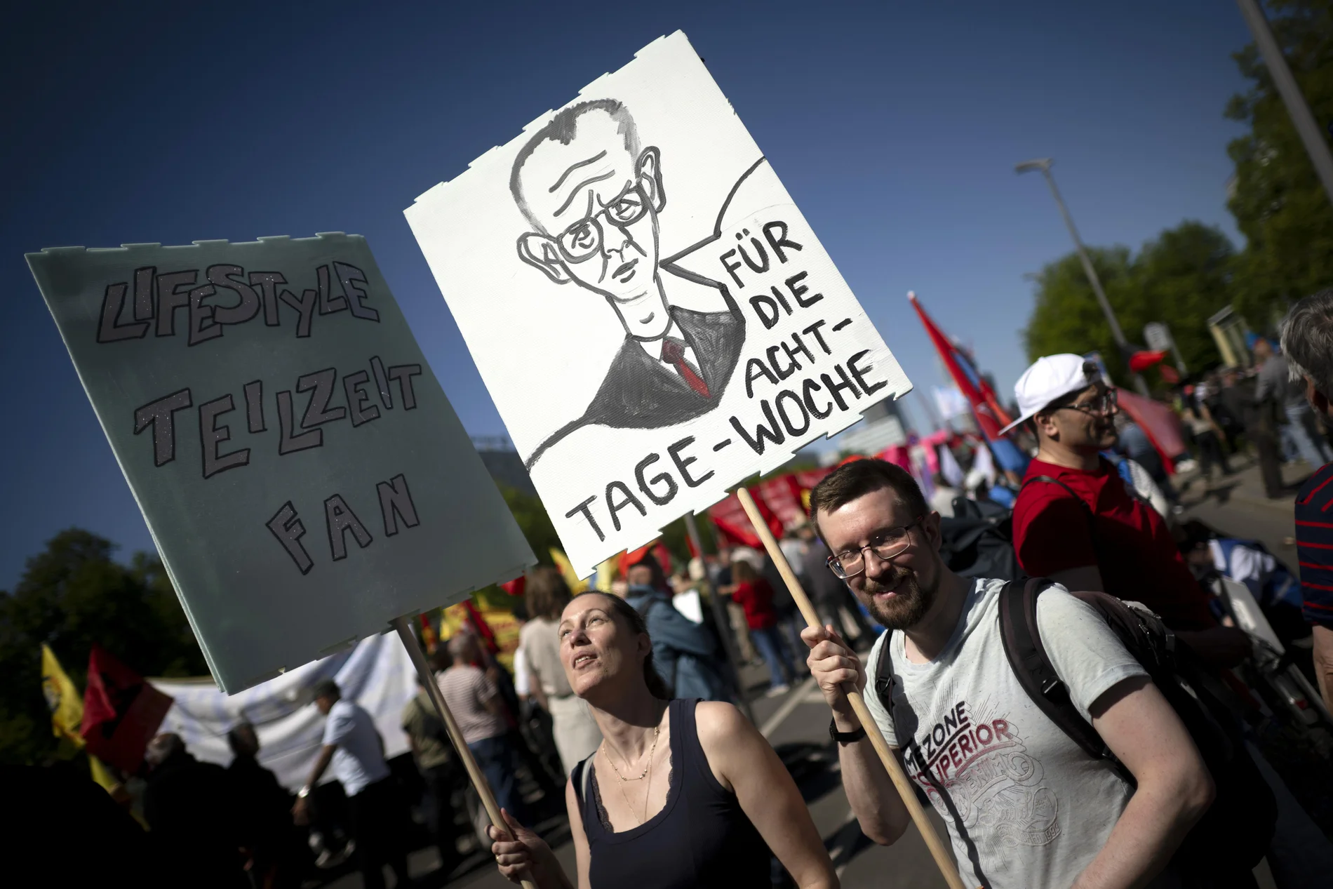 Demonstranten mit einem ironischen Schild "Für die Acht-Tage-Woche"