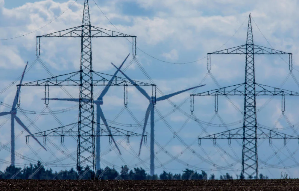 Masten von Stromferntrassen stehen vor einem Umspannungswerk