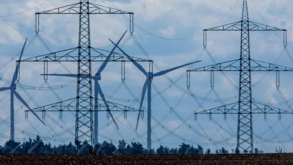 Masten von Stromferntrassen stehen vor einem Umspannungswerk