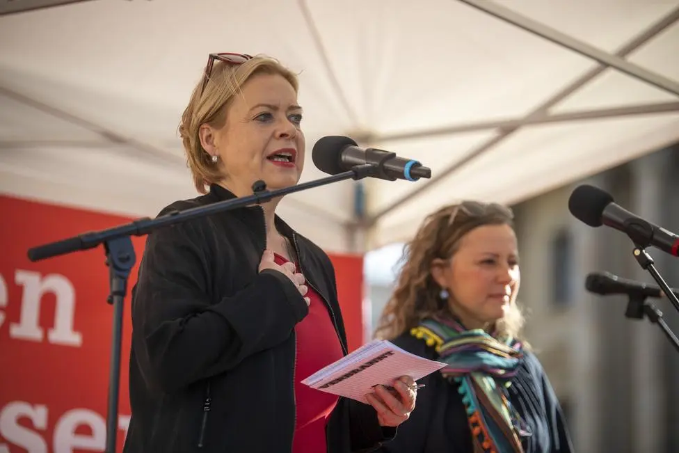 Gesine Lötzsch hält auf einer Bühne eine Ansprache. 