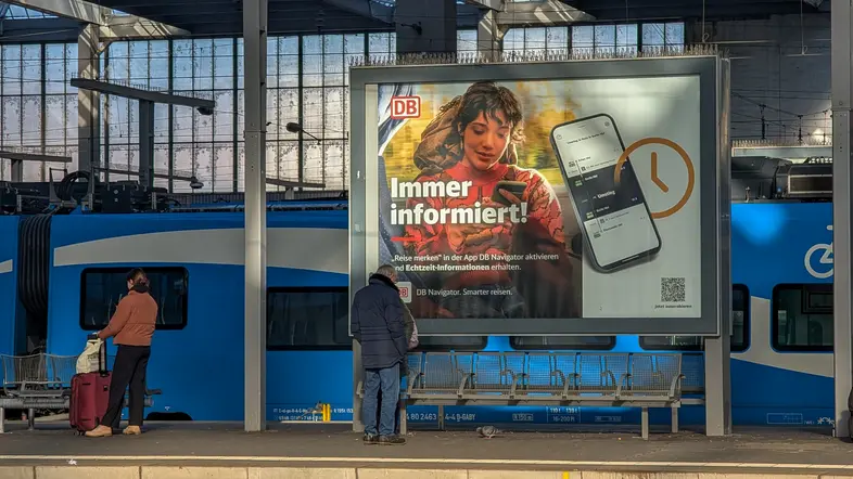 Eine digitale Werbeanzeige der DB auf einem Bahnsteig.