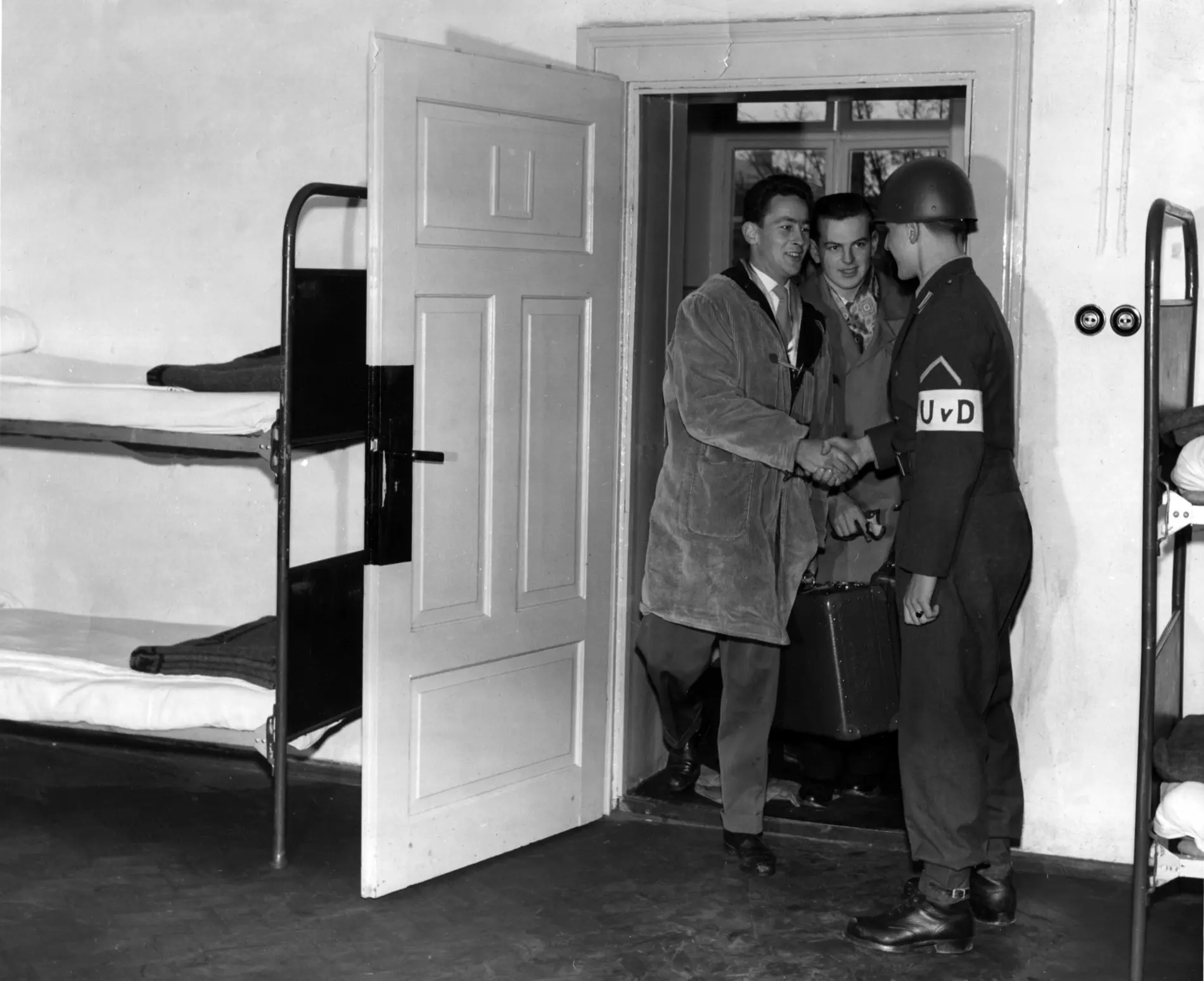 Am 1.4.1957 ziehen die ersten Wehrpflichtigen in die Kasernen der Bundeswehr ein. Zwei Wehrpflichtige werden mit einem Handschlag vom Unteroffizier begrüßt