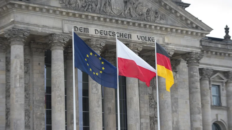  Die europäische, polnische und deutsche Flagge vor dem Reichstagsgebäude