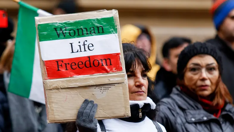 Frau Hält ein Schild mit der Aufschrift "Women, Life, Freedom"
