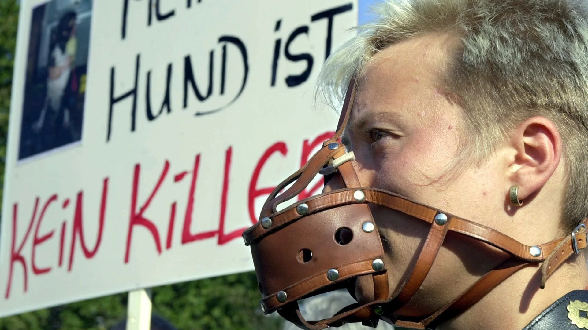 Frau mit Maulkorb demonstriert gegen das Kampfhunde-Verbot