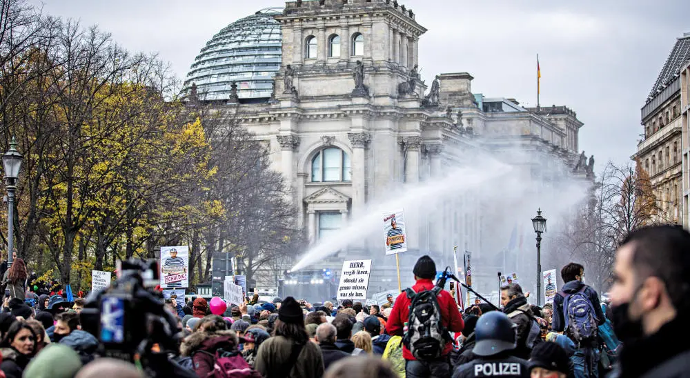 Demonstranten vor dem Reichstagsgebäude, die Polizei setzt Wasserwerfer ein. 