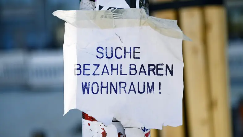 Flyer mit Aufschrift Suche bezahlbaren Wohnraum an einem Laternenmast.