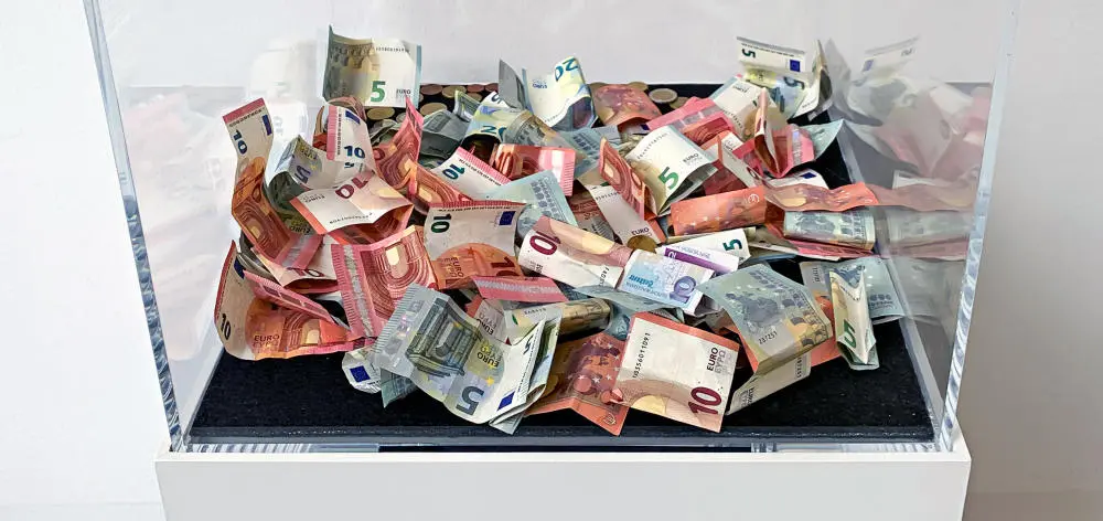 Mehrere 5- und 10-Euro-Scheine befinden sich in einer Glasvitrine