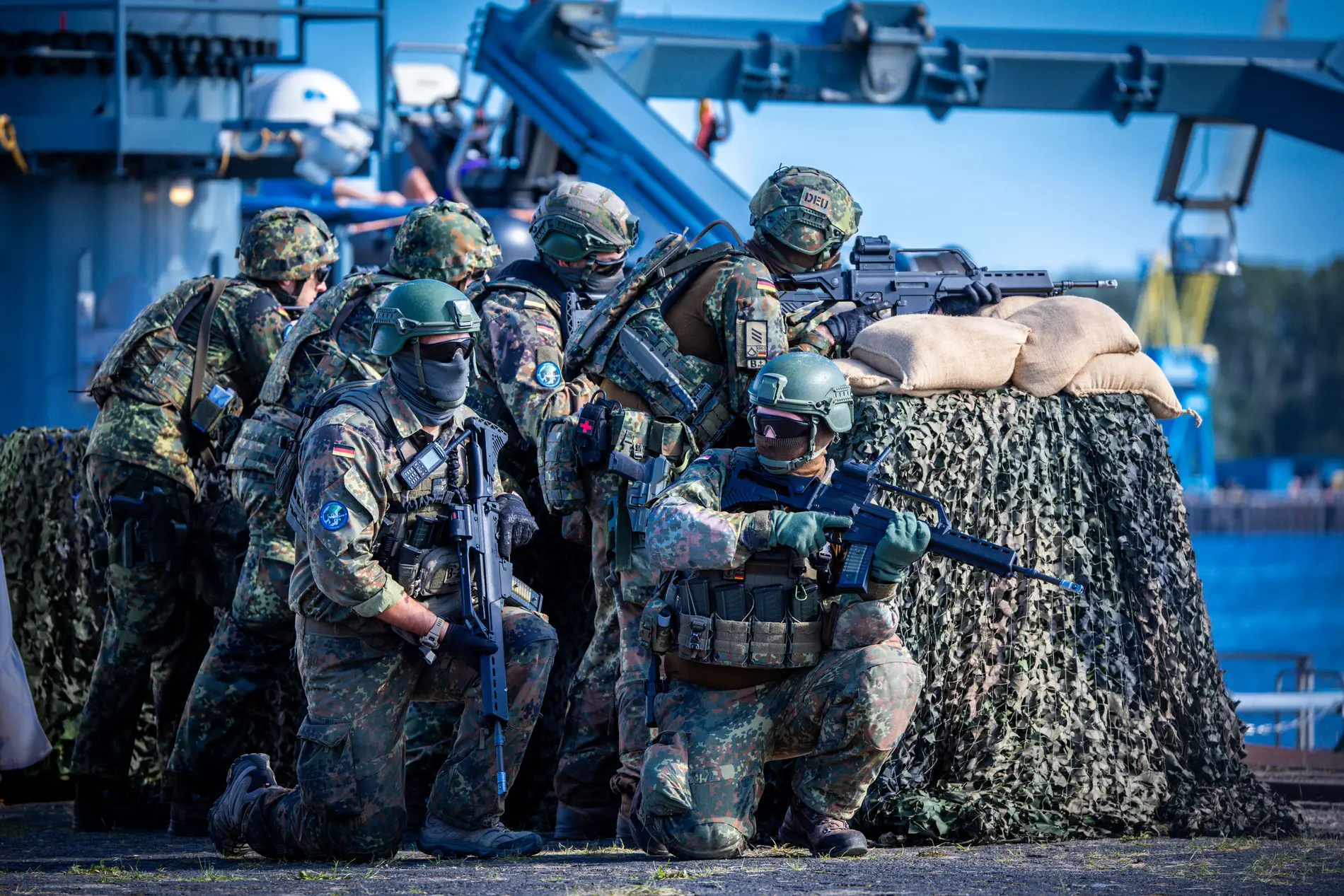 Einheiten der Bundeswehr sichern bei einem Übungsszenario im Hafen das Beladen und Ablegen des Transportschiffs mit Militärtechnik ab.