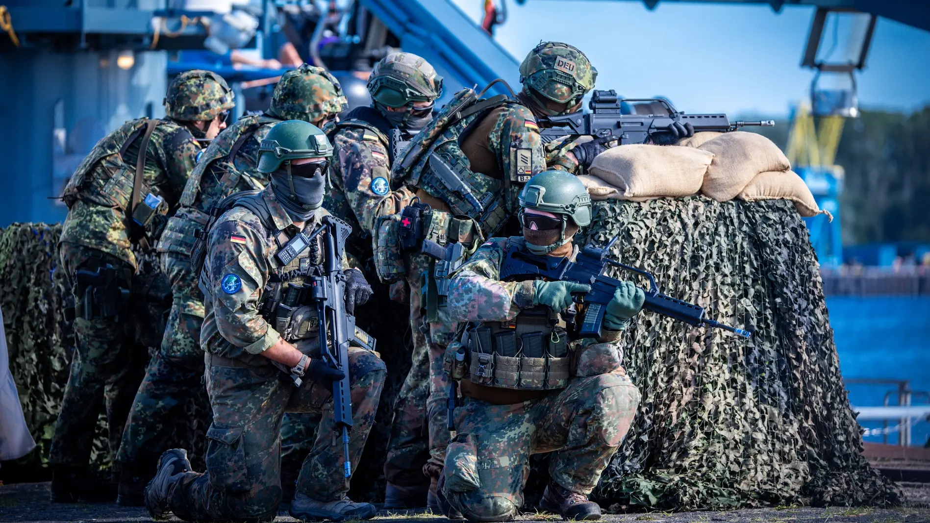 Einheiten der Bundeswehr sichern bei einem Übungsszenario im Hafen das Beladen und Ablegen des Transportschiffs mit Militärtechnik ab.