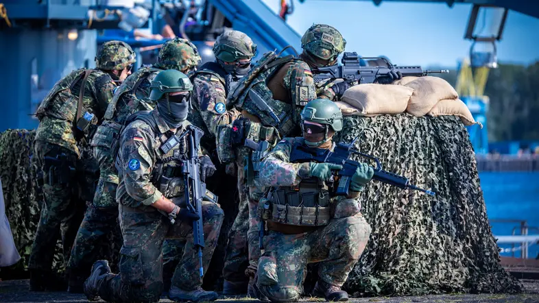 Einheiten der Bundeswehr sichern bei einem Übungsszenario im Hafen das Beladen und Ablegen des Transportschiffs mit Militärtechnik ab.