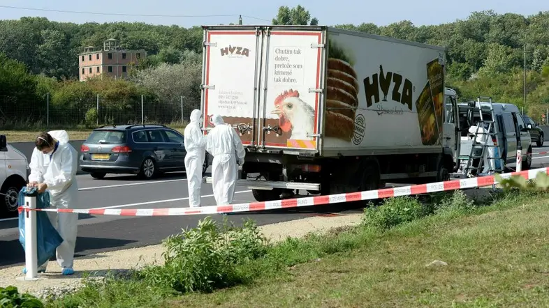 Ein Lastwagen auf einer befahrenen Autobahn, hinter Absperrband wird von der Kriminalpolizei untersucht.