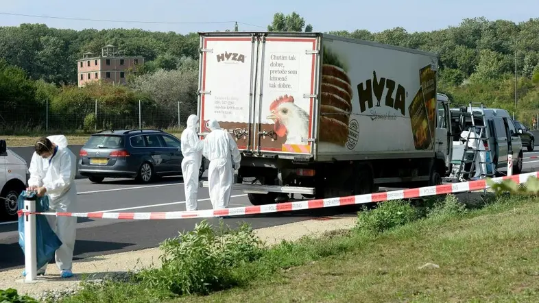Ein Lastwagen auf einer befahrenen Autobahn, hinter Absperrband wird von der Kriminalpolizei untersucht.