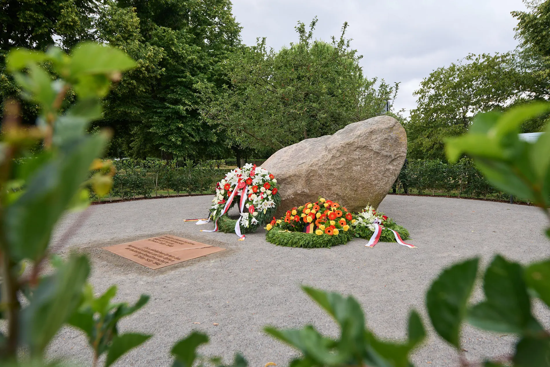 Gedenkstein mit Blumen davor