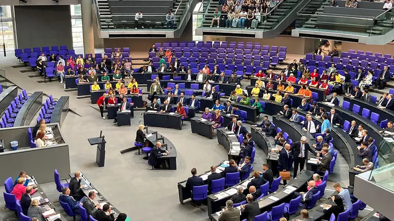  Abgeordnete von Linken und Grünen in Regenbogenfarben im Plenum