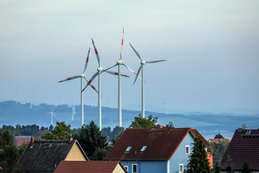Windräder hinter einer Wohnsiedlung
