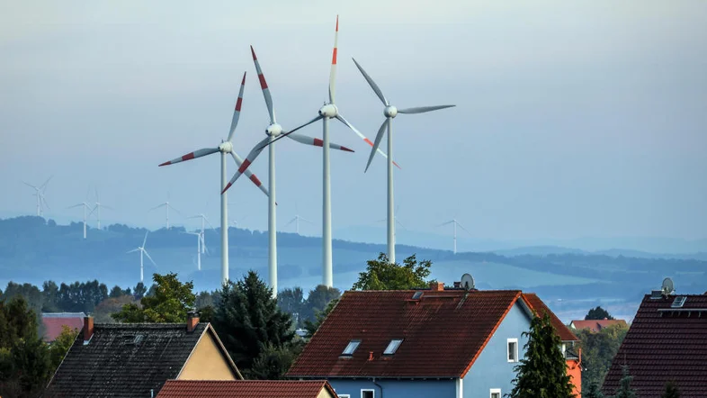 Windräder hinter einer Wohnsiedlung