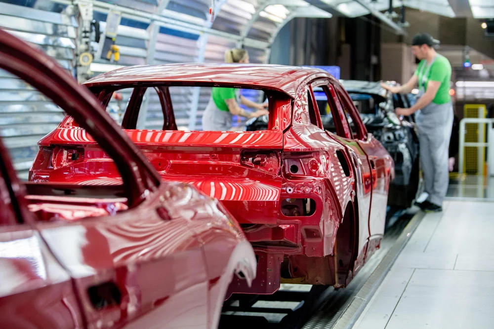 Mitarbeiter überprüfen den Lack einer Karosserie