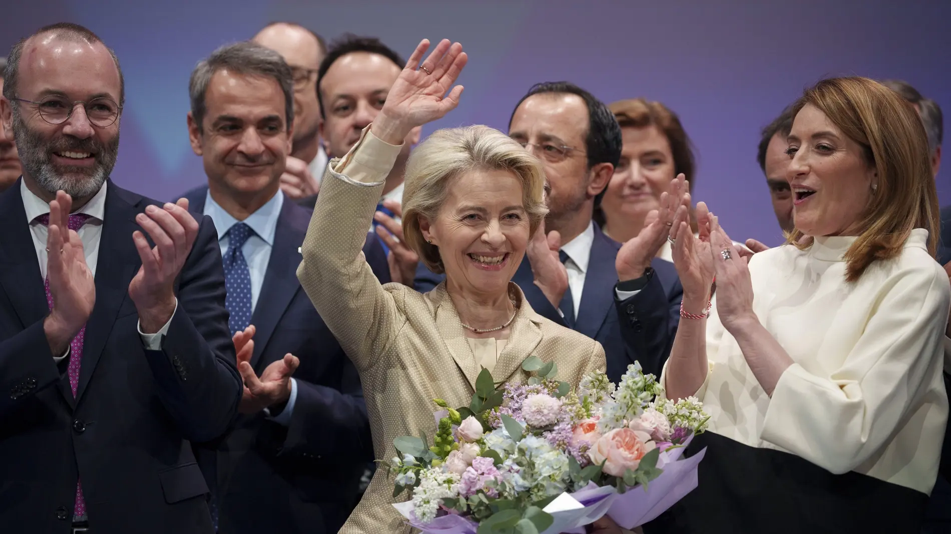 Ursula von der Leyen Ursula von der Leyen winkend mit einem Blumenstrauß, von Menschen umgeben
