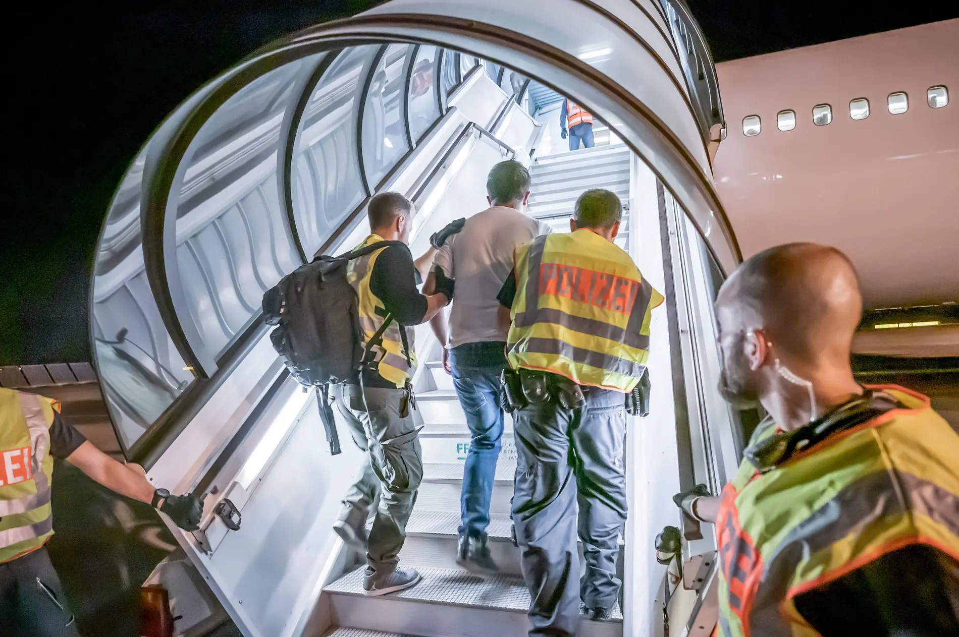 Rückführung eines Afghanen auf dem Flughafen Halle-Leipzig Polizeibeamte führen einen Mann eine Flugzeugtreppe hoch