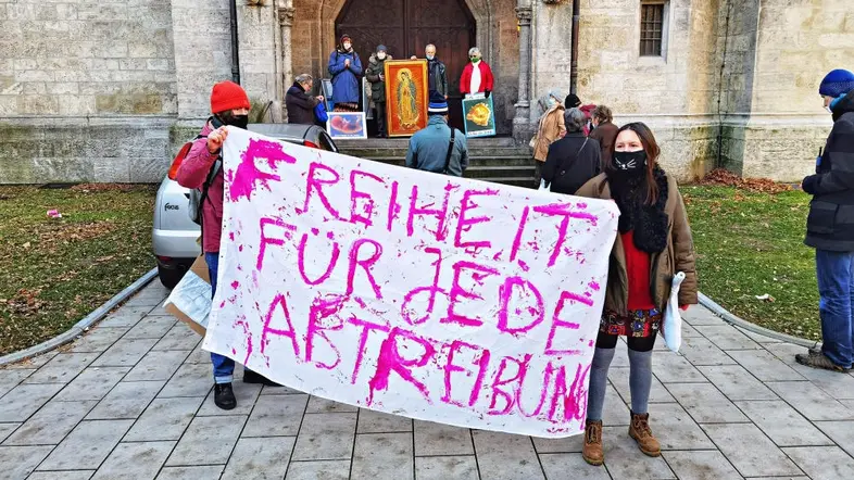 Personen halten ein Plakat mit der Aufschrift "Freiheit für jede Abtreibung"