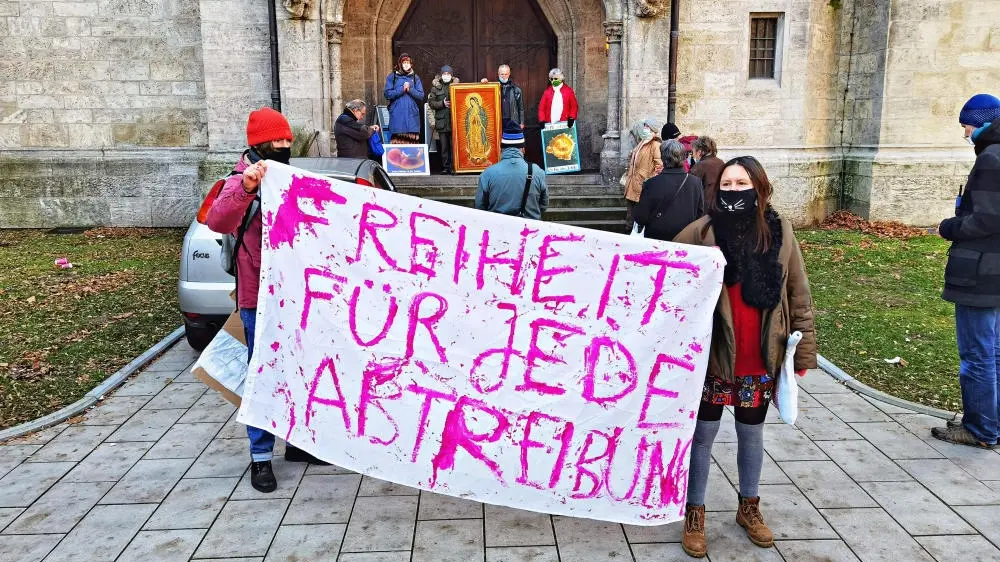 Personen halten ein Plakat mit der Aufschrift "Freiheit für jede Abtreibung"