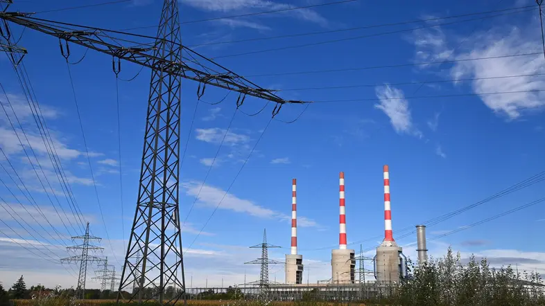 Das Kraftwerk Irsching mit Strommast und drei Schornsteinen