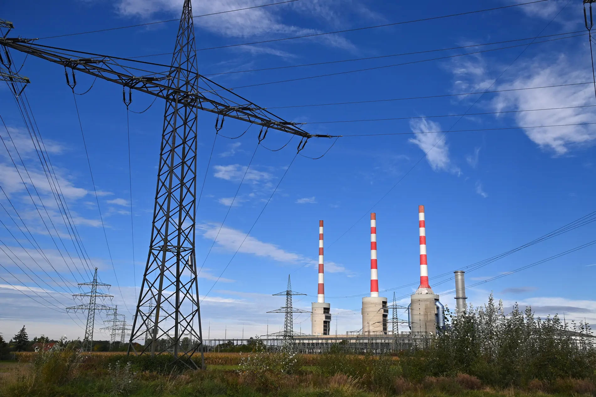 Das Kraftwerk Irsching mit Strommast und drei Schornsteinen