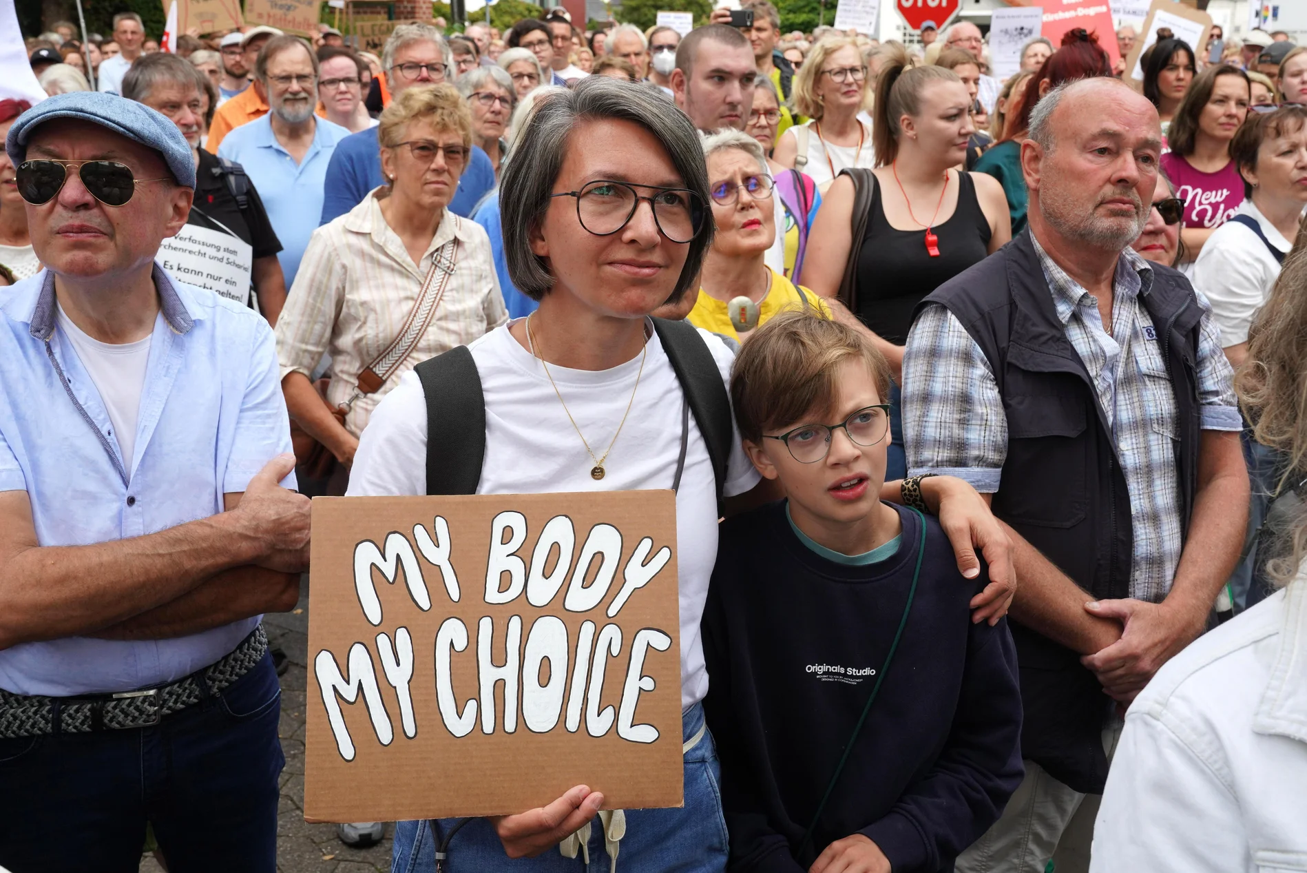 Eine Demonstrantin hält ein Plakat.